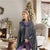 USB Heated Electric Shawl Blanket being worn by a woman in a cozy living room with holiday decorations.