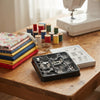 11-Piece Sewing Machine Presser Feet Kit displayed on a wooden table with fabric and sewing machine in the background.