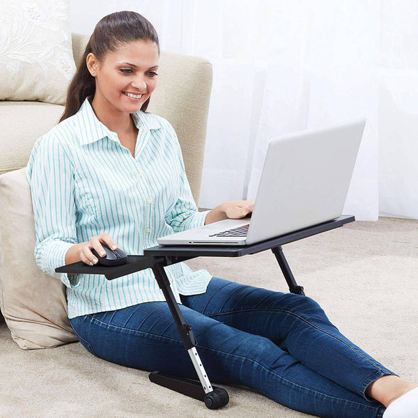 Woman using an Adjustable Laptop Desk while sitting on the floor, working comfortably with a laptop.