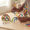 Child hands building structures with the 29-Piece Flexible Magnetic Building Rod Set on a wooden table.