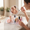 User applying makeup using the Acrylic Vanity Mirror Makeup Organizer on a vanity counter.