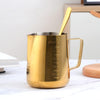 Gold Stainless Steel Milk Frothing Pitcher 350ML with handle and measurement markings on a tabletop.
