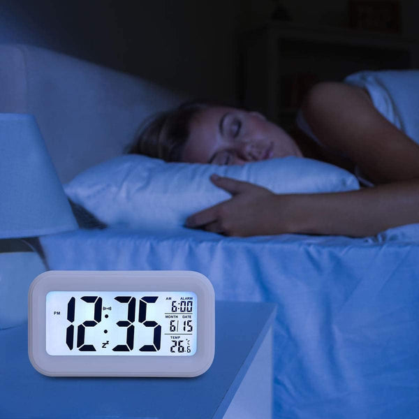 Smart Digital LCD Desk Clock with Temperature Display illuminating bedside in a dark room while a person peacefully sleeps.