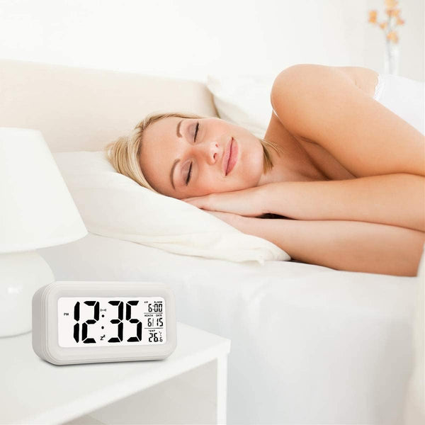 Smart Digital LCD Desk Clock with Temperature Display beside a woman sleeping peacefully in a modern bedroom.