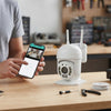 Person using smartphone to monitor the 1080P HD Wireless Outdoor PTZ Security Camera.