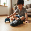 A young boy playing with the Black Racer Remote Control Toy Car and controller on the floor.