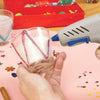 Person using a Colored Hot Glue Stick Set for DIY Crafts and Decorations to decorate a glass candle holder.