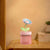 Flower Design Mini USB Air Humidifier & Aroma Diffuser on a bedside table with a warm background.