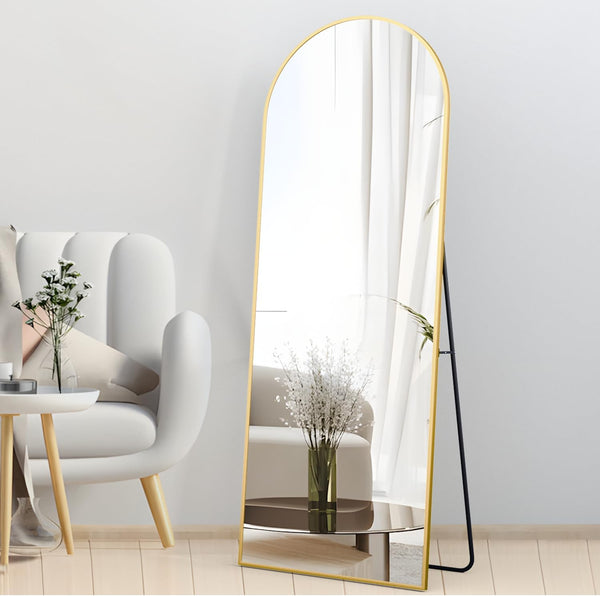 Arched Full Length Floor Mirror with Gold Frame leaning against wall in modern living room decor.