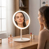 Woman applying makeup using the Glow Mate USB Rechargeable LED Vanity Mirror on a wooden desk.