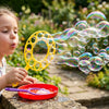 Child blowing bubbles with a Bubble Wand and Tray Set in a garden, enjoying outdoor bubble-making fun.