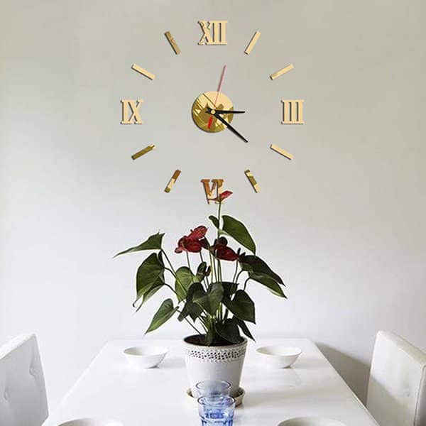 3D DIY Mirror Golden Surface Wall Clock Roman Numeral above a potted plant on a dining table.