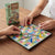Mini Magnetic Snakes & Ladders Board Game with players rolling dice and moving pieces on a colorful board.