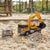 Remote Control Construction Vehicle Excavator Truck Play Set in sandbox with remote control and safety cones.