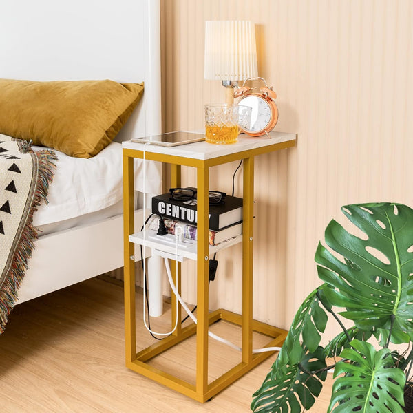 C Shaped Side Table with Charging Station beside a bed, showcasing stylish design and charging cables.