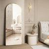 Arched Full Length Floor Mirror with Gold Frame in a modern bedroom setting, reflecting light and enhancing the space.