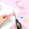 Person using Multi-Size Stainless Steel Professional Scissors to cut a pink ribbon on a white fabric.