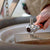 Person using the 48 in 1 Multifunctional Universal Rotating Socket Wrench on a wooden surface.