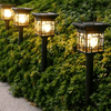 2-Pack Solar Garden Lights illuminating a pathway among lush greenery for outdoor ambiance.