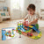 Child playing with Funny City Track 41-Piece Flexible Track Playset in a bright room with colorful track pieces and car.