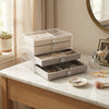 3-Tier Clear Acrylic Jewelry Box with Velvet Drawers displaying organized jewelry on a marble table.