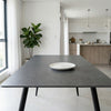 6 Seater Dining Table with plate on top, modern design in bright dining space with greenery.
