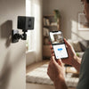 Person using smartphone to monitor the 2MP 1080P Security Camera in a modern living room.