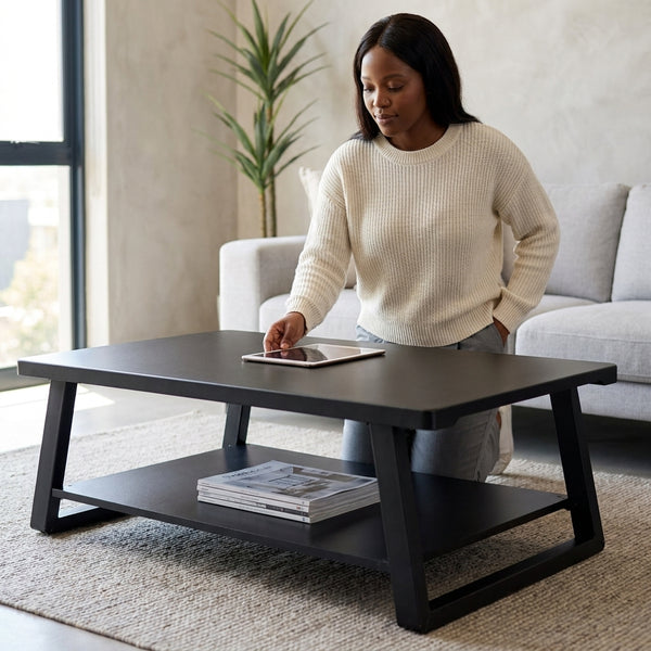 Woman using tablet on Industrial Minimalist Wood & Metal Coffee Table in modern living room setting.