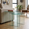 3 Piece Nesting Coffee Table Set displayed next to a sofa with a glass top and decorative books.