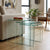 3 Piece Nesting Coffee Table Set displayed next to a sofa with a glass top and decorative books.