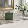 Clear Ribbed Acrylic Storage Box with Dust-Proof Lid displayed on a bathroom counter alongside a green box and flowers.