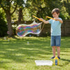 Child using the Double Bubble Giant Bubble Wand to create a giant bubble in a garden.