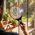 Person using a Rechargeable Electric Mosquito Killer Racket Fly Swatter to eliminate flies indoors.