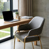Sunpan Malachi Dining Armchair in a modern office setting with a laptop and a plant on the desk.