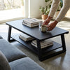 Industrial Minimalist Wood & Metal Coffee Table in a modern living room with books and coffee cup.