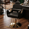 Reclining Hydraulic Salon Styling Chair in a modern salon setting, featuring gold accents and a sleek black design.