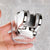 Adjustable Punch-Free Shower Head Wall Bracket in chrome finish held in hand against a marble background.