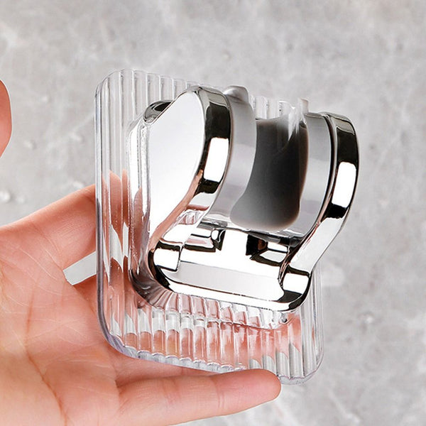 Adjustable Punch-Free Shower Head Wall Bracket in chrome finish held in hand against a marble background.