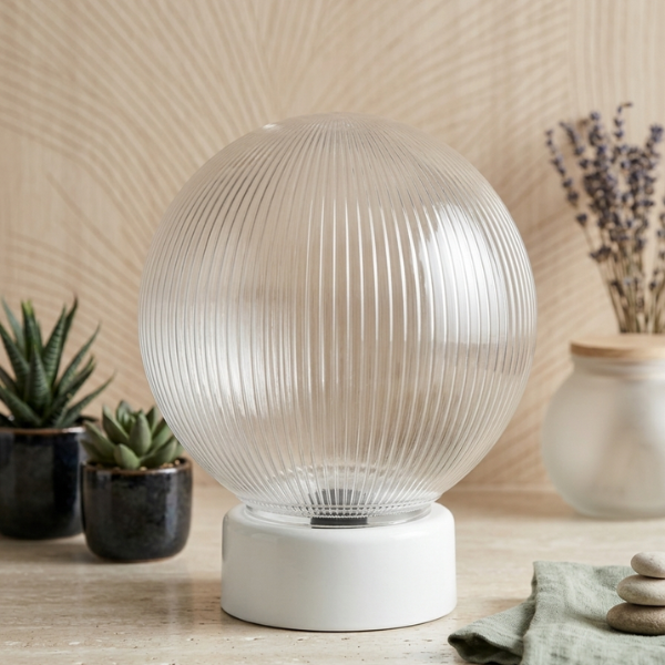 Clear Ribbed Glass Globe Pendant Lampshade on a white base with plants in the background, showcasing modern interior lighting.