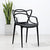 Cafe Replica Master Chair in black against white wall with a plant in a pot.