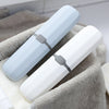 Compact Travel Toothbrush & Utensil Storage Case in blue and white on a towel.