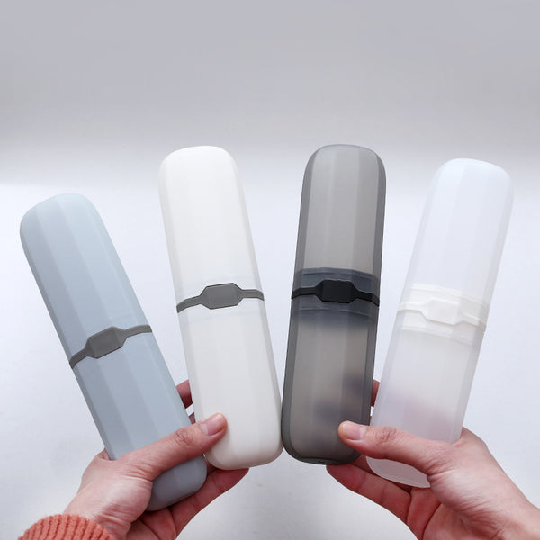 Compact Travel Toothbrush & Utensil Storage Case in grey, white, transparent, and dark grey colors held in hands.