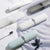 Compact Travel Toothbrush & Utensil Storage Case in various colors on a soft surface with a toothbrush.
