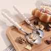 Elegant Pearl-Handled Stainless Steel Cutlery Set with spoons and snacks on a wooden tray