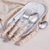 Elegant Pearl-Handled Stainless Steel Cutlery Set displayed on a marble plate, featuring a knife, fork, and spoons.