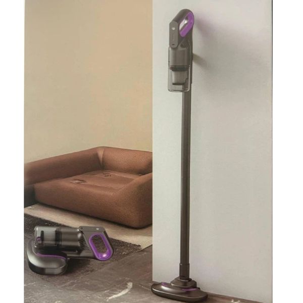 Mite Remover 2 in 1 Cordless Vacuum Cleaner standing beside a couch, showcasing its sleek design and cordless feature.