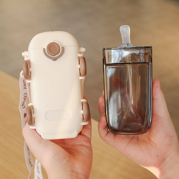 Fun Cartoon 500 ml Kids Water Bottle in a cheerful bus design, held in hands with a clear straw included.