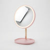 Round Makeup Mirror with Storage Tray featuring a pink freestanding design and integrated storage tray.