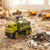 Alloy Tractor Head Watering Truck Play Set featuring a miniature watering truck spraying water on sandy terrain.