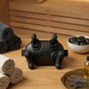 4-Head Handheld Body Massager on a wooden table surrounded by towels and stones, perfect for home relaxation and massage.